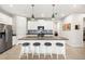 Modern kitchen with white cabinets, a large center island, and stainless steel appliances, perfect for cooking at 12538 Somatic Ct, Venice, FL 34293