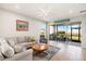 Comfortable living room featuring neutral decor, tile flooring, and seamless access to the screened lanai at 12538 Somatic Ct, Venice, FL 34293