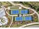 Aerial shot of community tennis and bocce ball courts surrounded by lush landscaping at 12538 Somatic Ct, Venice, FL 34293