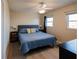 Comfortable bedroom with a queen-size bed, ceiling fan, and natural light from the dual windows at 1255 Tarpon Center Dr # 604, Venice, FL 34285