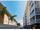 Exterior view of beachfront condominiums with stucco walls, balconies, and tropical landscaping along a paved drive at 1255 Tarpon Center Dr # 604, Venice, FL 34285