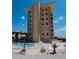 Exterior of a modern beachfront condominium complex featuring a pool, lounge area, and beach access at 1255 Tarpon Center Dr # 604, Venice, FL 34285