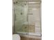 Modern bathroom features a glass enclosed shower with stone flooring, marble walls, and a built-in bench at 1255 Tarpon Center Dr # 604, Venice, FL 34285