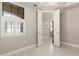 Bright bedroom with tray ceilings, tiled floors, plantation shutters and doors leading to the main living area at 13829 Alafaya St, Venice, FL 34293