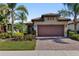 Charming home features a two-car garage, tile roof, lush landscaping, and a brick paver driveway at 13829 Alafaya St, Venice, FL 34293