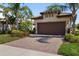 Beautiful home showcasing a brick driveway and lush landscaping at 13829 Alafaya St, Venice, FL 34293