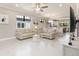 Bright living room with tile floors, neutral paint, and a view into the kitchen and dining areas at 13829 Alafaya St, Venice, FL 34293