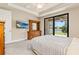 Spacious bedroom with a sliding glass doors to the backyard, TV, and wood furniture at 13829 Alafaya St, Venice, FL 34293