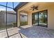 Screened-in patio with brick flooring, ceiling fan, and lush landscaping at 13829 Alafaya St, Venice, FL 34293