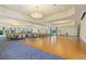 Large ballroom with wood dance floor and blue carpet, decorated with elegant lighting at 1438 Maseno Dr, Venice, FL 34292