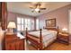 Comfortable bedroom featuring a ceiling fan, plantation shutters, and wooden furniture at 1438 Maseno Dr, Venice, FL 34292