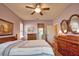Bedroom view with a ceiling fan, wall art, and stylish wood furnishings at 1438 Maseno Dr, Venice, FL 34292
