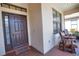 A cozy front porch showcasing a tile floor, comfortable seating, and a beautiful entrance door at 1438 Maseno Dr, Venice, FL 34292