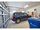 Spacious garage featuring ample storage shelves, a car, and a blue county trash bin at 1438 Maseno Dr, Venice, FL 34292