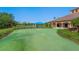 Outdoor putting green and lakeside gazebo with a clubhouse in the background at 1438 Maseno Dr, Venice, FL 34292