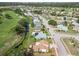 An aerial view showcases a neighborhood near a golf course, canal, and tree lined streets at 1439 Strada D Argento, Venice, FL 34292