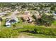 Aerial view showcases a home with a backyard, patio, and nearby stream in a residential neighborhood at 1439 Strada D Argento, Venice, FL 34292