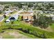 Aerial view showcases a home with a backyard, patio, and nearby stream in a residential neighborhood at 1439 Strada D Argento, Venice, FL 34292