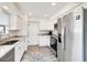Clean kitchen featuring stainless steel appliances, bright cabinetry, and elegant countertops at 1439 Strada D Argento, Venice, FL 34292