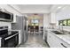 Bright kitchen features stainless appliances, marbled countertops, and wood-look flooring at 1439 Strada D Argento, Venice, FL 34292
