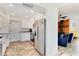 Clean kitchen with stainless appliances and wood-look flooring adjacent to the living room at 1439 Strada D Argento, Venice, FL 34292