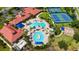 Aerial view of community pool, tennis courts, lawn games, and clubhouse with red tile roof at 1481 Hyssop Loop, North Port, FL 34289