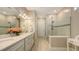 Spacious bathroom featuring double sinks and walk-in shower with glass doors at 1481 Hyssop Loop, North Port, FL 34289