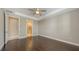 Open bedroom with dark hardwood floors, ceiling fan, and ensuite bathroom at 1481 Hyssop Loop, North Port, FL 34289