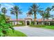 Clubhouse entrance with terracotta roof and arched doorway surrounded by palm trees at 1481 Hyssop Loop, North Port, FL 34289