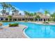 Inviting community pool with tropical landscaping, clear blue water, and a spacious deck area for sunbathing at 1481 Hyssop Loop, North Port, FL 34289