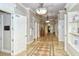 Long hallway with beautiful tile flooring and trim, leading to various rooms in the building at 1481 Hyssop Loop, North Port, FL 34289