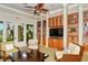 Well-stocked library with built-in bookshelves, comfortable chairs, and a large television for entertainment at 1481 Hyssop Loop, North Port, FL 34289