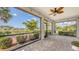 Enclosed patio overlooks the lawn and pond surrounded by palm trees and lush landscaping at 1481 Hyssop Loop, North Port, FL 34289