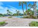 A luxurious pool with lush landscaping, comfortable seating, and paver stone decking at 1481 Hyssop Loop, North Port, FL 34289