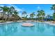 A luxurious community pool with tropical landscaping and comfortable seating areas at 1481 Hyssop Loop, North Port, FL 34289