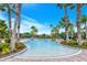 Large community pool surrounded by lush palm trees and beautiful landscaping at 1481 Hyssop Loop, North Port, FL 34289