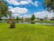 Backyard view of houses with a pond and blue sky, providing serene and picturesque scenery at 1493 Maseno Dr, Venice, FL 34292