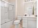 Bright bathroom featuring a shower with sliding doors, a toilet, sink with vanity and a large mirror at 1493 Maseno Dr, Venice, FL 34292