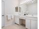 Bright bathroom featuring double sinks, a vanity area, and ample storage space in white cabinetry at 1493 Maseno Dr, Venice, FL 34292