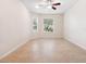 Neutral bedroom featuring tile flooring, ceiling fan, and two large windows at 1493 Maseno Dr, Venice, FL 34292