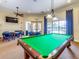 Spacious game room with a pool table, ceiling fan, mounted TV, and chairs with tables at 1493 Maseno Dr, Venice, FL 34292