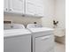 Bright laundry room featuring a washer, dryer, sink, and cabinets for plenty of storage space at 1493 Maseno Dr, Venice, FL 34292