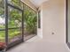 Screened patio showcasing a tranquil backyard view with lush palm trees and a serene lake at 1493 Maseno Dr, Venice, FL 34292