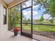 Screened patio offering peaceful water views, overlooking a well-maintained yard and a picturesque lake at 1493 Maseno Dr, Venice, FL 34292