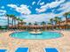 Beautiful community pool surrounded by palm trees, lounge chairs, and covered seating areas at 1493 Maseno Dr, Venice, FL 34292