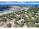 Aerial view showing the property's location amidst lush trees, nearby community, and clear blue skies at 1515 Pecan St, Nokomis, FL 34275