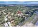 Aerial view showcasing the home's location within a tree-lined neighborhood near an open field at 1515 Pecan St, Nokomis, FL 34275
