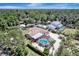 Aerial view of a home with a screened pool, lush landscaping, and ample parking on a sunny day at 1515 Pecan St, Nokomis, FL 34275