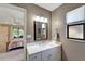 Neutral-toned bathroom with vanity sink, modern lighting, a decorative mirror, and an adjacent bedroom at 1515 Pecan St, Nokomis, FL 34275