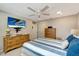 Comfortable bedroom with a ceiling fan, television, and light wood dresser at 1515 Pecan St, Nokomis, FL 34275